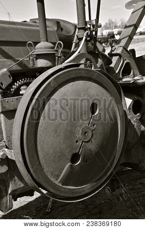 A Very Old Fly Wheel Of A A Tractor Which Provides Power And Compression(black And White)