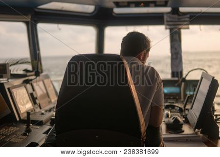 Deck Navigation Officer On The Navigation Bridge. He Looks At Radar Screen. Watchkeeping, Collision 