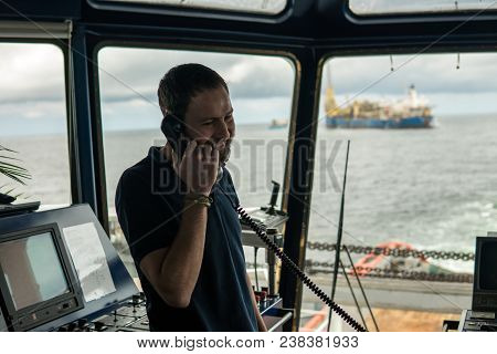 Deck Navigation Officer On The Navigation Bridge. He Speaks By Vhf Radio, Gmdss Watchkeeping, Collis