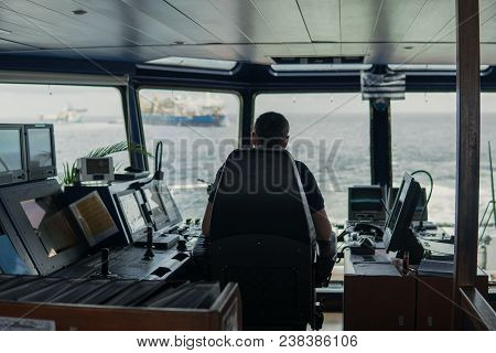 Deck Navigation Officer On The Navigation Bridge. He Looks To Sea. Watchkeeping, Collision Preventio