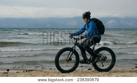 Fat Bike Also Called Fatbike Or Fat-tire Bike In Summer Driving On The Beach. The Guy Is Going Strai