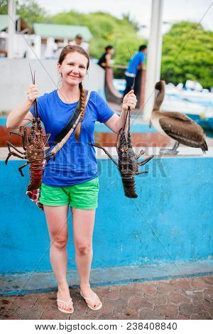 Woman holding fresh lobsters at seafood market