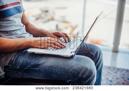 Young Man Using Laptop In Airport Terminal.