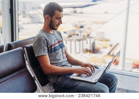 Young Man Using Laptop In Airport Terminal.