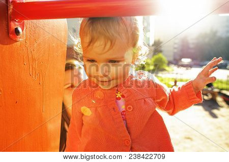 Little Girl With Mother Outside Walking At Playgarden