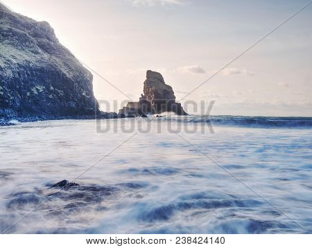Sea Stack Sharp Silhouette By Sunset Sky. Evening Light On The Rocks, Boulders And Cliff Face Of Tal