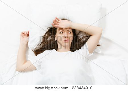 Top View Tired Brunette Young Woman Looking Aside, Lying In Bed With White Sheet, Pillow, Blanket. S