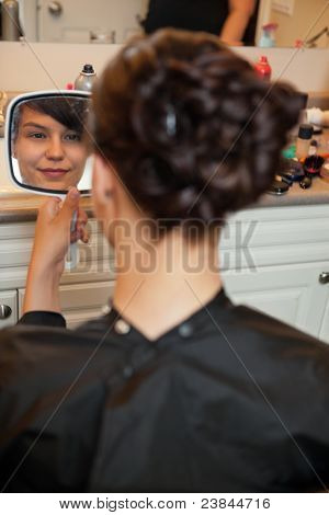 Nevěsta hledá v zrcadle na styl vlasy před svatbou