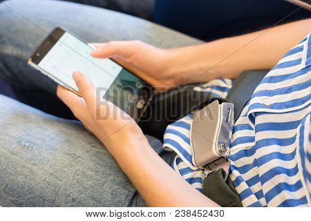 Fashionable Casualy Dressed Female Passenger With Seat Belt Fastened Switching Mobile Phone To Fligh