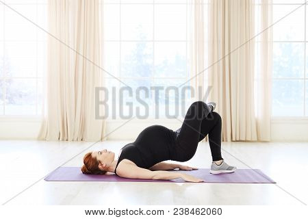 Beautiful Pregnant Woman Practicing Prenatal Yoga Or Pilates Lying On Back Exercising With Upper Bod