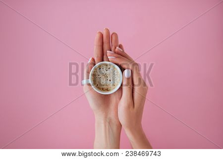 Cup Of Coffee In Beautiful Female Hands With Stylish Manicure. Pink Background. Flat Lay Style.