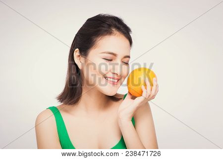 Beautiful Asian Portrait Of Young Woman With Oranges. Healthy Food Concept. Skin Care And Beauty. Vi