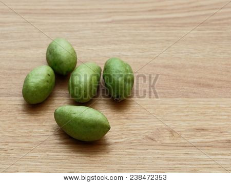A Group Of Green Hog Plums Fruit, Which Look Like Small Mango, Over Bright Wooden Background With Co