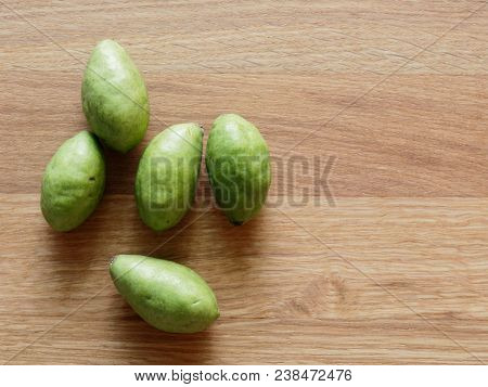 A Group Of Green Hog Plums Fruit, Which Look Like Small Mango, Over Bright Wooden Background With Co