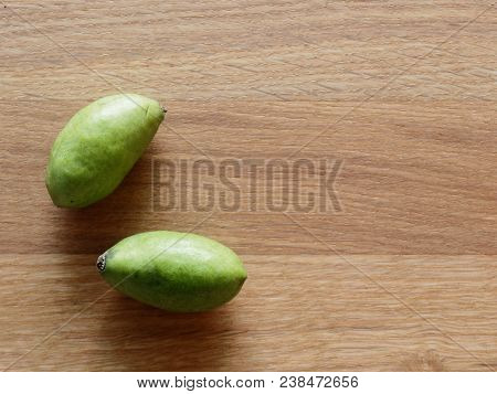 A Group Of Green Hog Plums Fruit, Which Look Like Small Mango, Over Bright Wooden Background With Co