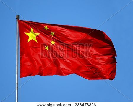 National Flag Of China On A Flagpole In Front Of Blue Sky.