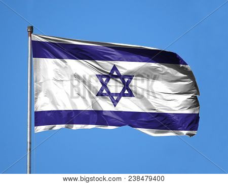 National Flag Of Israel On A Flagpole In Front Of Blue Sky.