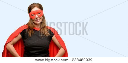 Middle age super hero woman wearing red mask and cape confident and happy with a big natural smile laughing isolated blue background