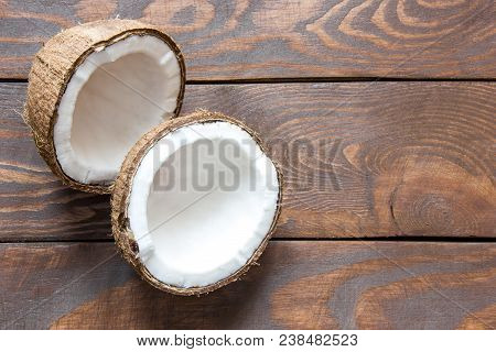 Two Halves Of Fresh Coconut Lie On A Wooden Table, There Is A Place For An Inscription