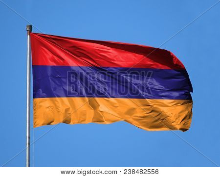 National Flag Of Armenia On A Flagpole In Front Of Blue Sky.