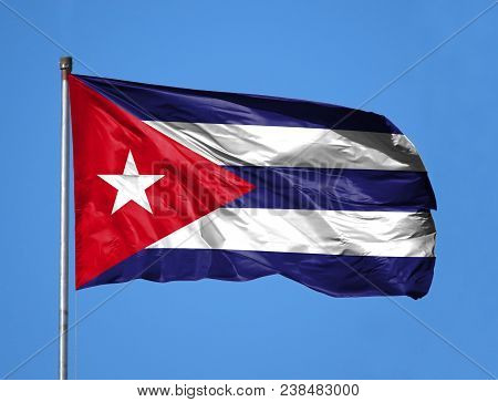 National Flag Of Cuba On A Flagpole In Front Of Blue Sky.