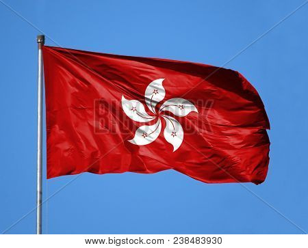 National Flag Of Hong Kong On A Flagpole In Front Of Blue Sky.
