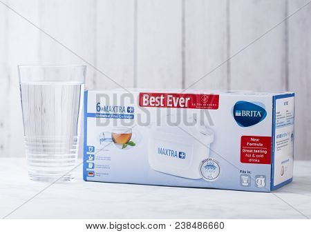London, Uk - April 27, 2018: Glass Of Water With Pack Of Brita Water Filter Cartridges On Wooden Bac