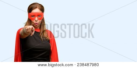 Middle age super hero woman wearing red mask and cape pointing to the front with finger isolated blue background