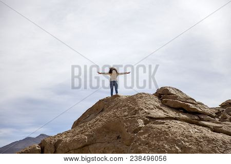 Young Woman At Ock Formations Of Dali Desert In Bolivia At Eduardo Avaroa Andean Fauna National Rese