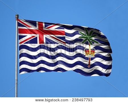 National Flag Of British Territory In The Indian Ocean On A Flagpole In Front Of Blue Sky.