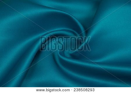 Smooth Blue Satin Silk Fabric. Folds, Curl. Satin Background.