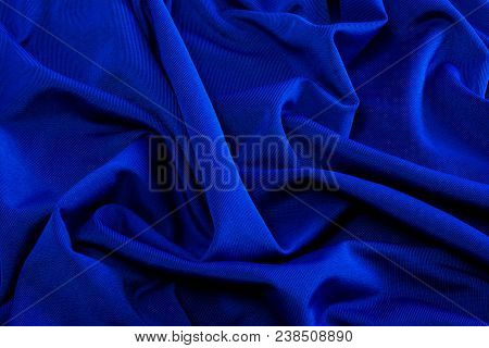 Smooth Blue Satin Silk Fabric. Folds, Curl. Satin Background.