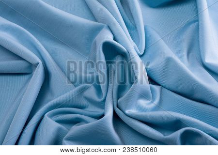 Smooth Blue Satin Silk Fabric. Folds, Curl. Satin Background.