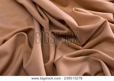 Smooth Beige Satin Silk Fabric. Folds, Curl. Satin Background.
