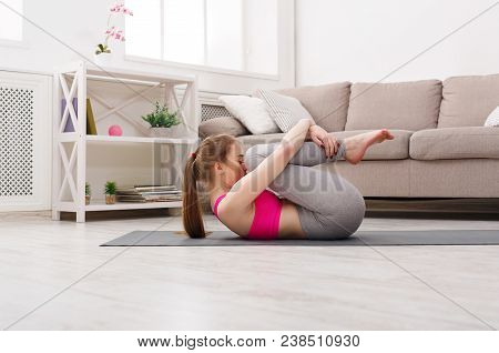 Fitness, Woman Yoga Relax Meditation In Wind-relieving Pose At Home. Young Slim Girl Makes Exercise.