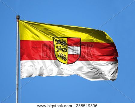 National Flag Of Carinthia On A Flagpole In Front Of Blue Sky.
