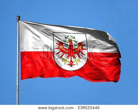 National Flag Of Tyrol Tirol On A Flagpole In Front Of Blue Sky.