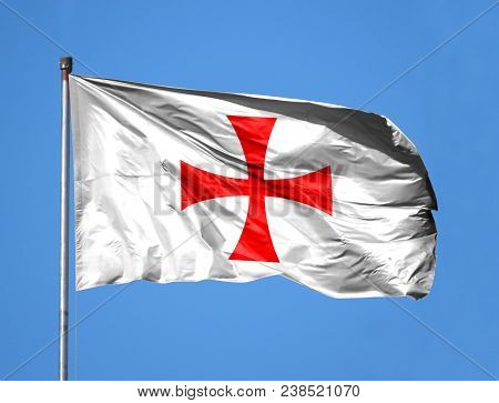 National Flag Of Templiers On A Flagpole In Front Of Blue Sky.