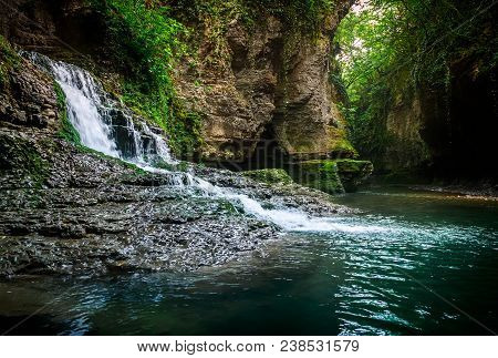 Amazing Forest Waterfall Flowing Into The Cold Mountain River With Large Stones. Martvili Canyon.
