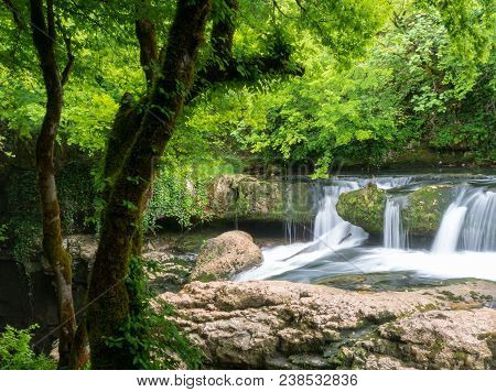 Amazing Forest Waterfall Flowing Into The Cold Mountain River With Large Stones. Martvili Canyon.