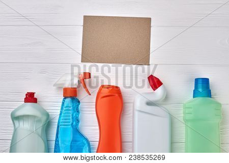 Plastic Containers With Cleaning Liquid. Set Of House Cleaning Supplies On White Wooden Table With P