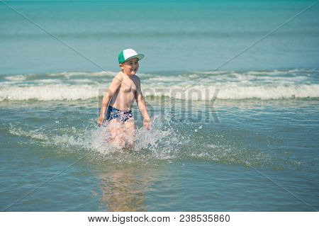 Littl Boy Is Running Along The Beach Playing And Splashing In Water Of Adriatic Sea In Durres, Alban