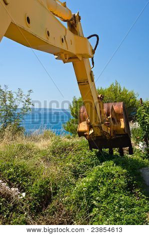 Vecchio sporco escavatore in riva al mare