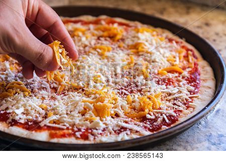 Making Pizza. Cook's Hand Sprinkles Cheese. American Style, Cooking In A Baking Dish