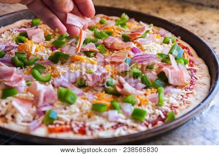 Making Pizza. Cook's Hand Sprinkles Bacon And Bell Pepper. American Style, Cooking In A Baking Dish