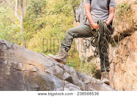 The Climber Holds The Rope, Stands On A Rock.