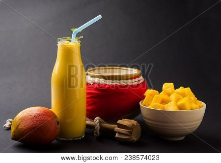 Mango Lassi Or Smoothie In Big Glass Or Small Bottles With Curd, Cut Fruit Pieces And Blender. Moody