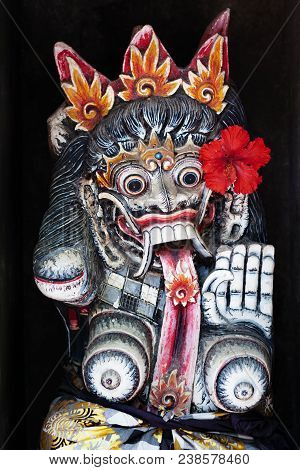 Old Figure Of Traditional Balinese Hindu Spirit Rangda On Wall Of Village Temple At Bali Island. Dec