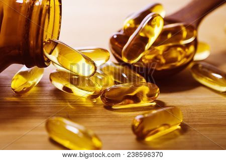 Close Up Vitamin D And Omega 3 Fish Oil Capsules Supplement On Wooden Plate For Good Brain , Heart A
