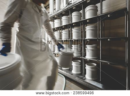 Man Sends Plastic Molds With Cheese On The Press. Press The Liquid Out Of The Cheese. Traditional Ch
